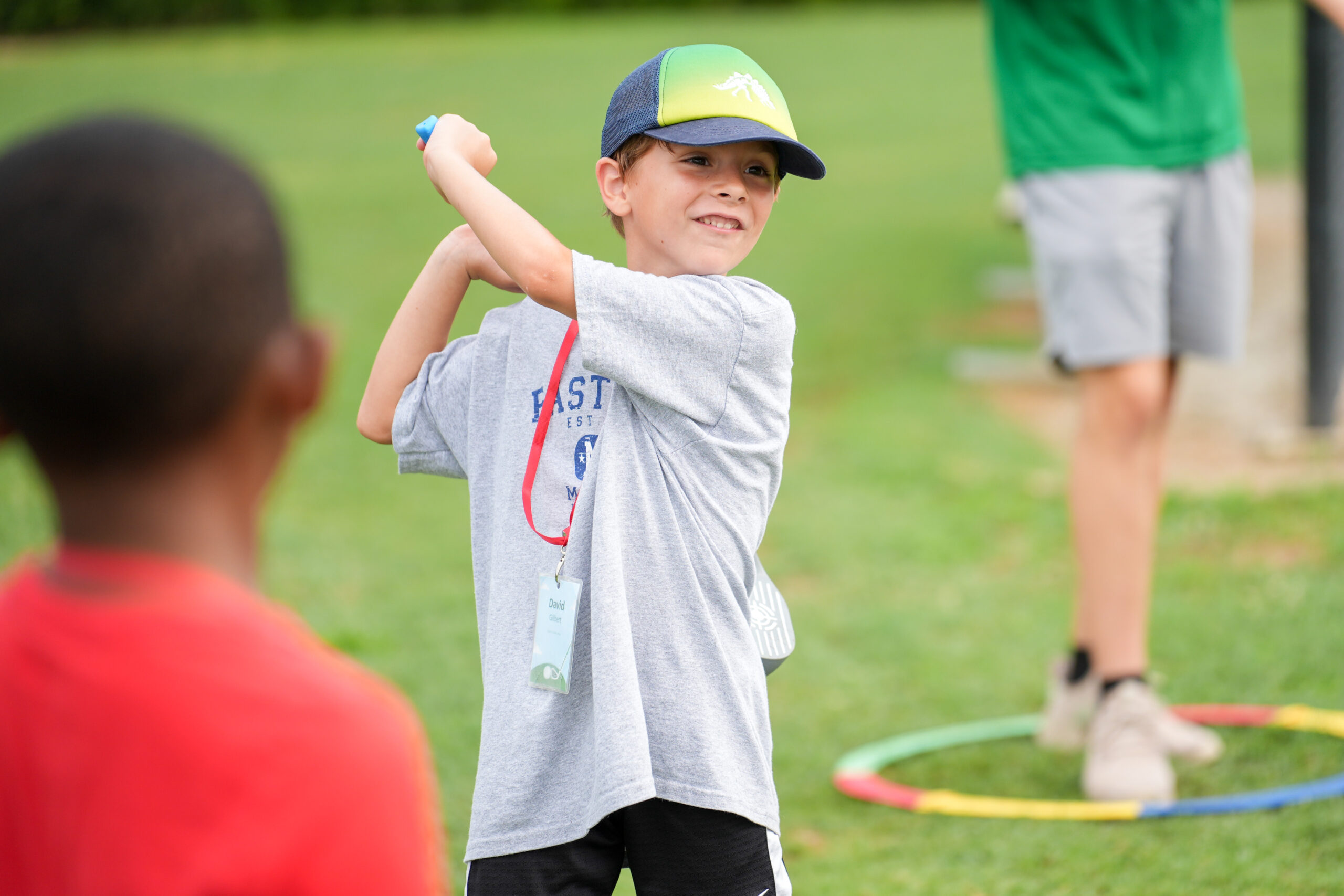 Coach helping a child with their golf technique at G1 Golf camp