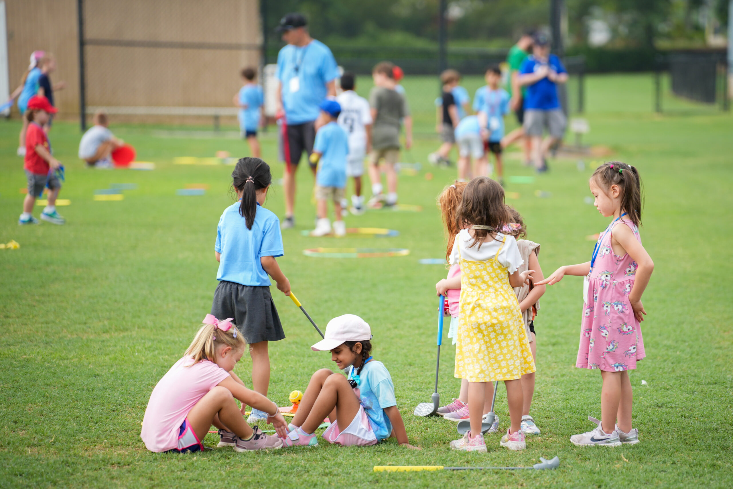 Kids rotating through G1 Golf stations in a gymnasium