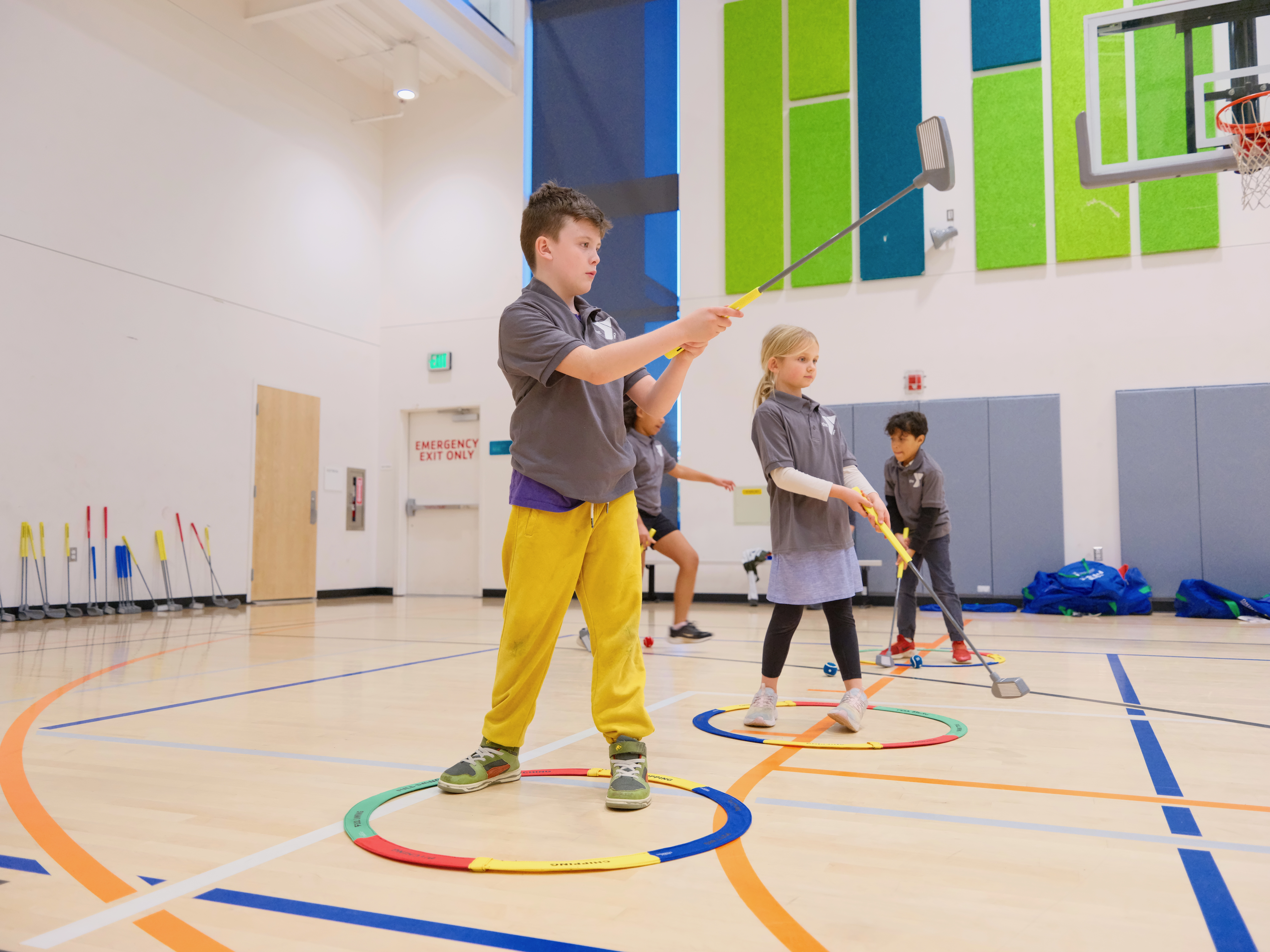 G1 Golf camp activity — children learning golf at a community center
