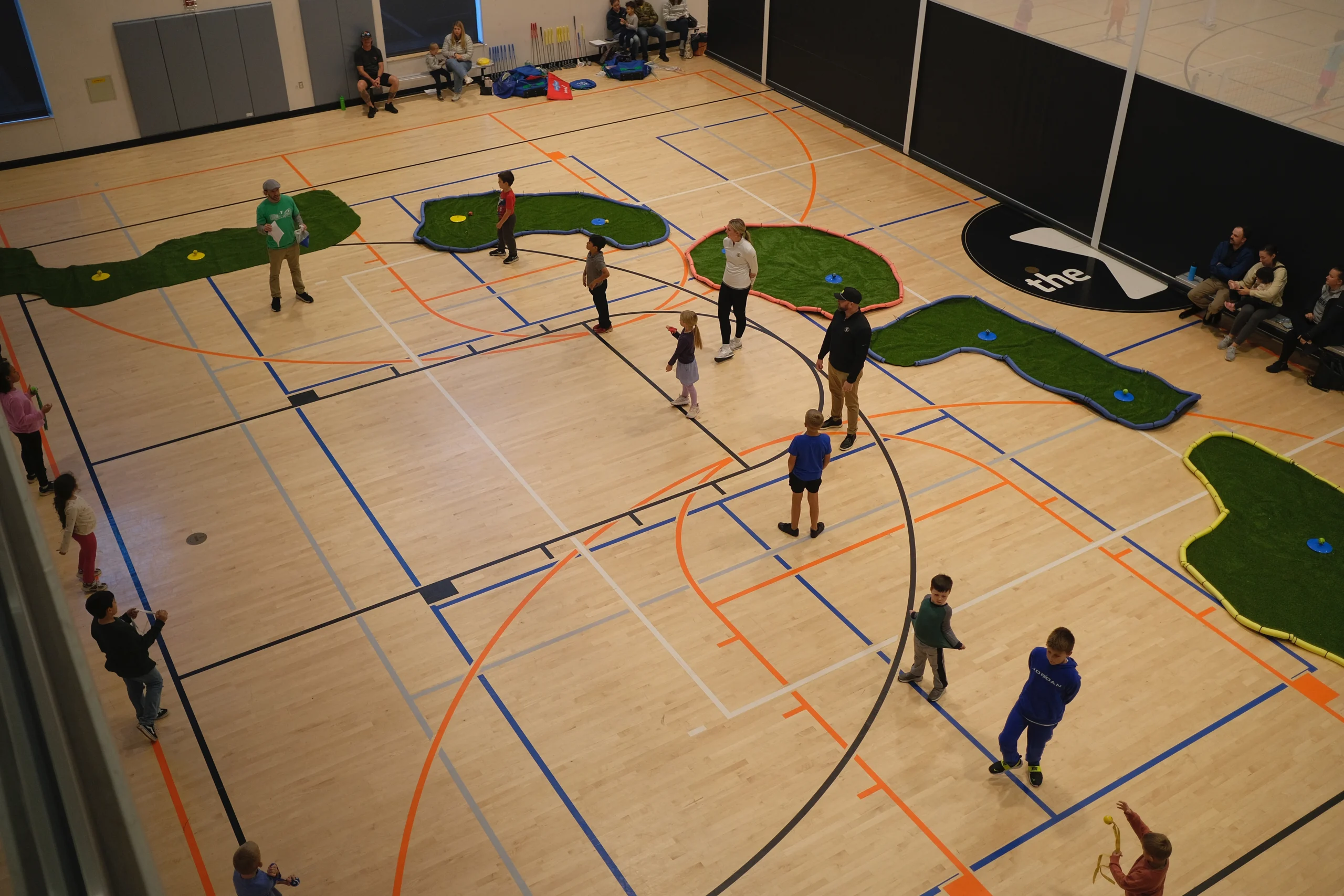 Young child practicing golf swing with modified equipment